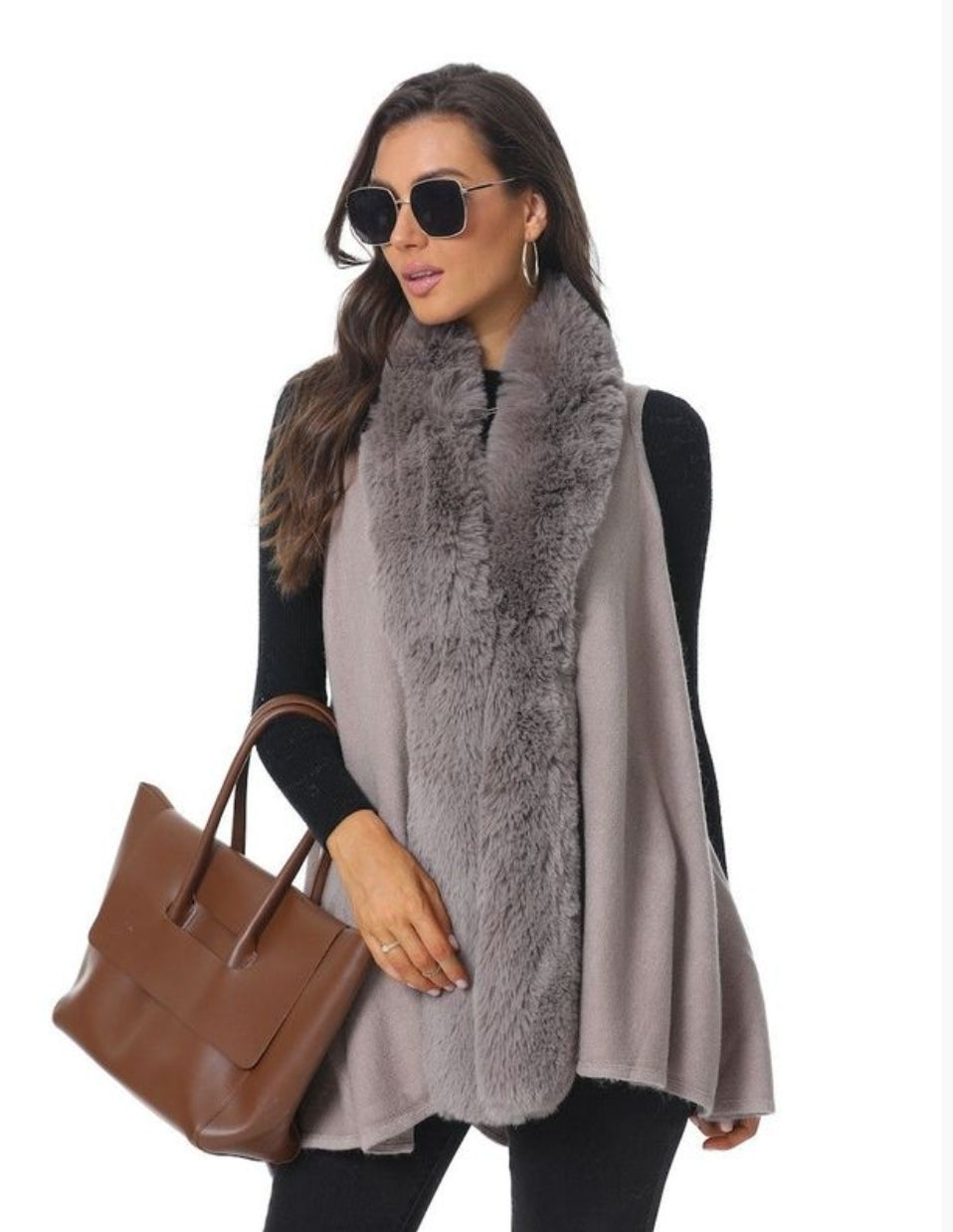 Woman wearing vest with fur trim, sunglasses, and holding a brown purse.