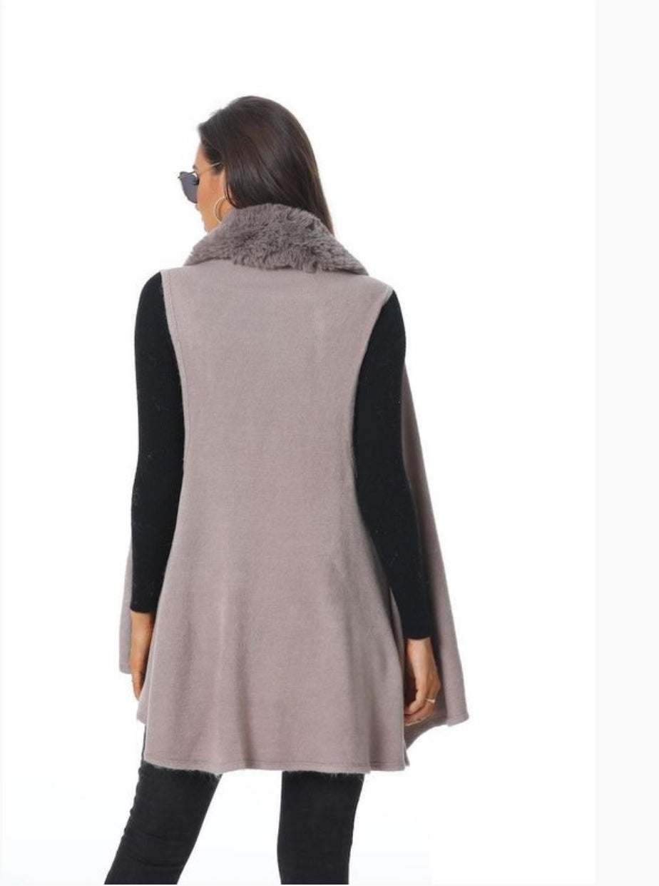 Woman wearing a fur-collared vest and black sleeves.