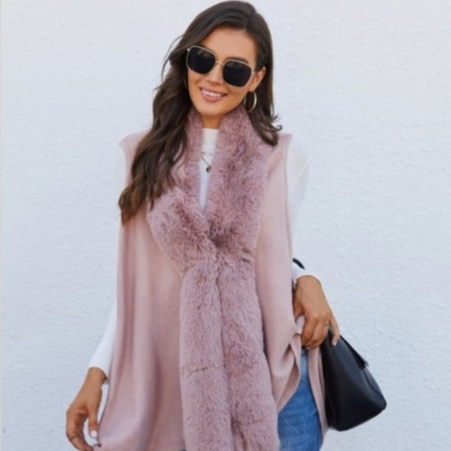 Woman in sunglasses and pink vest with fur collar.