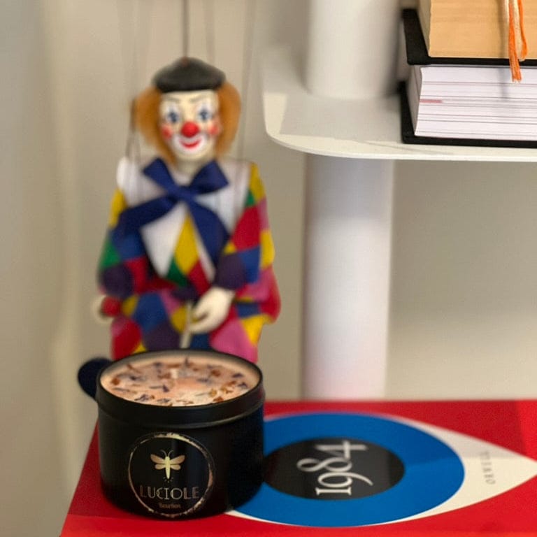 Clown puppet and candle on a shelf