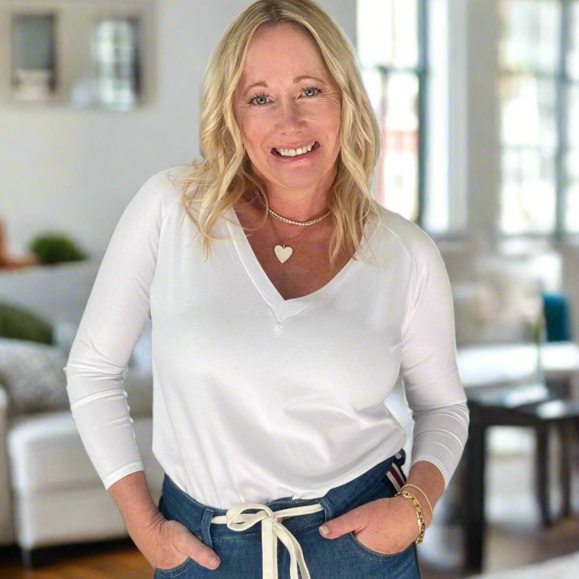 Woman smiling in white shirt and jeans