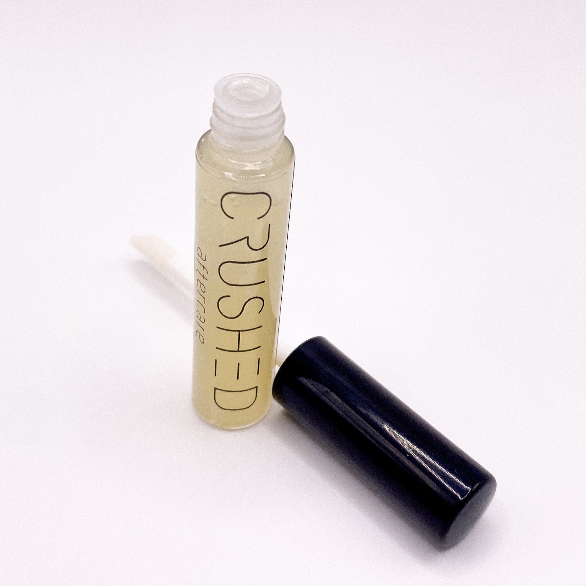Open bottle of CRUSHED aftercare product with cap.