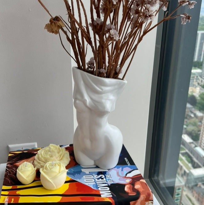 Peony flowers in white vase with book