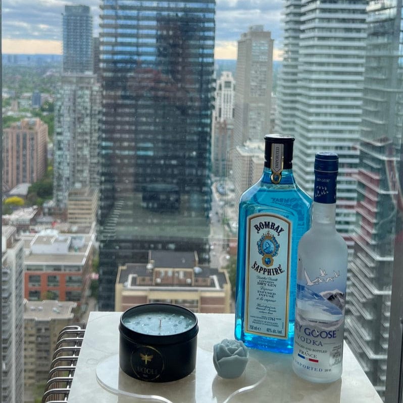 Bombay Sapphire gin and Grey Goose vodka bottles on a city backdrop