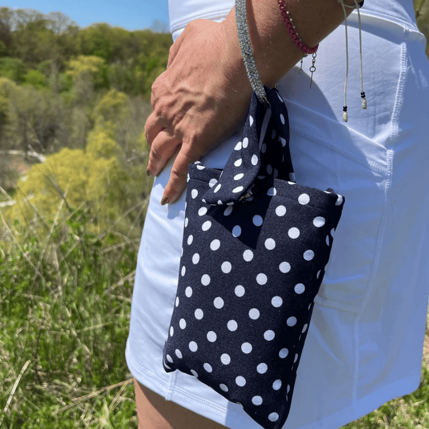 Woman holding navy polka dot bag, June 12, 2025 screenshot.