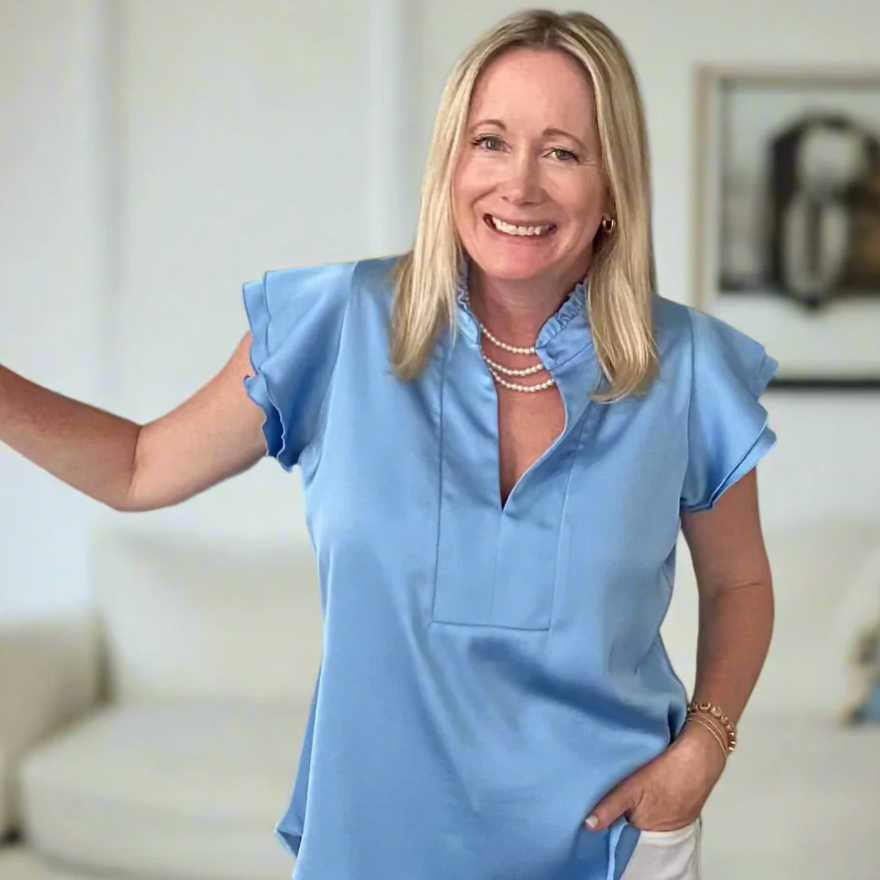 Woman in blue top smiling, screenshot July 9, 2025