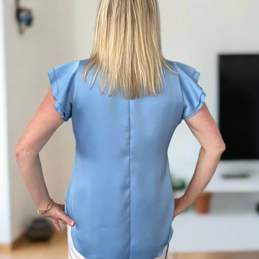 Woman in blue top, back view, Screenshot July 9, 2025