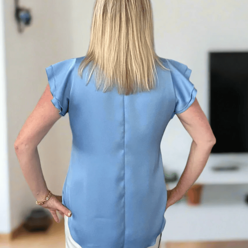 Woman in blue top, back view, Screenshot July 9, 2025