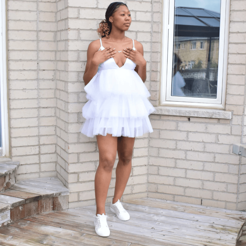 Woman in white dress and sneakers, screenshot July 16, 2025.