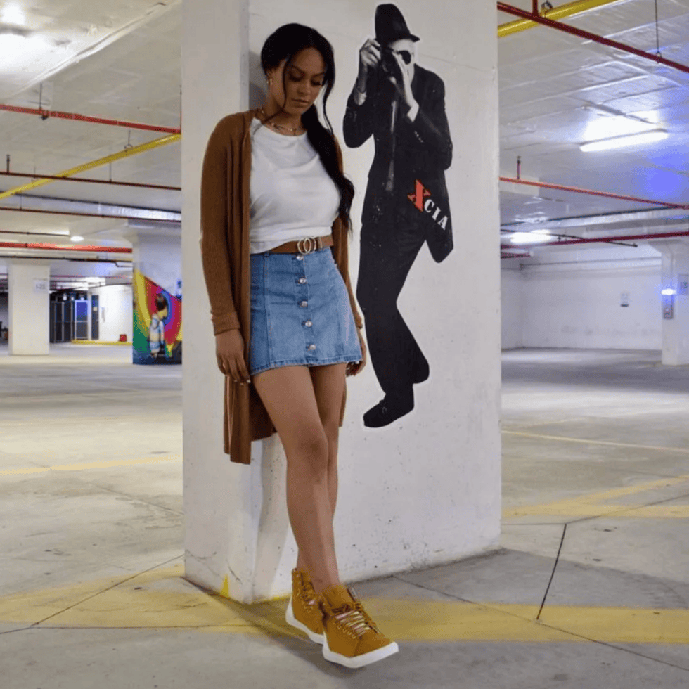 Woman in denim skirt poses by mural, July 16, 2025.