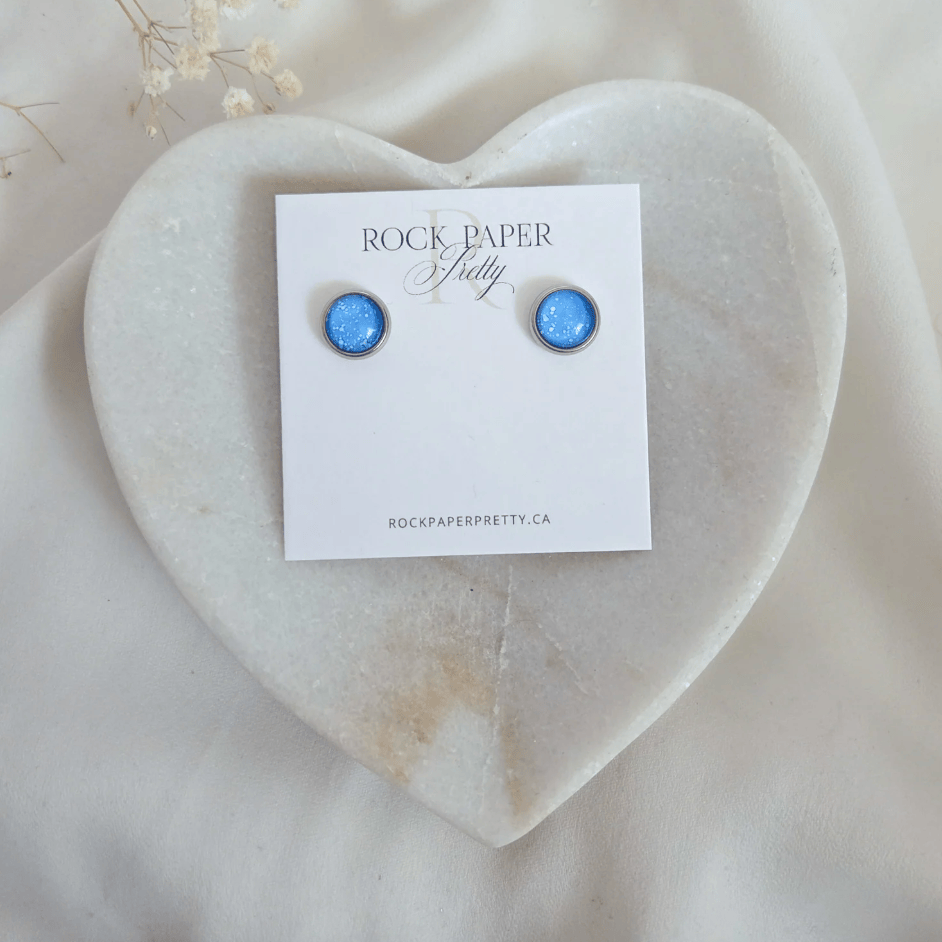 Blue stud earrings on heart-shaped tray, July 21, 2025 screenshot.