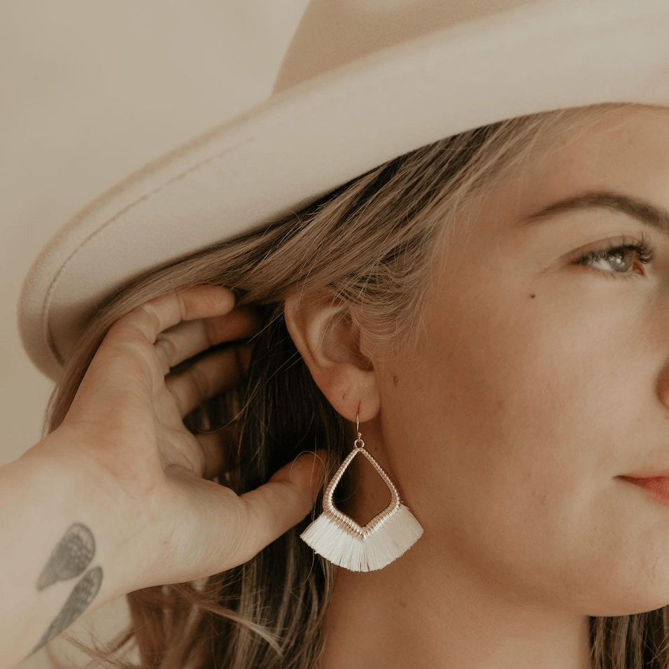 Woman wearing white fringe earrings, Screenshot Aug 22, 2025