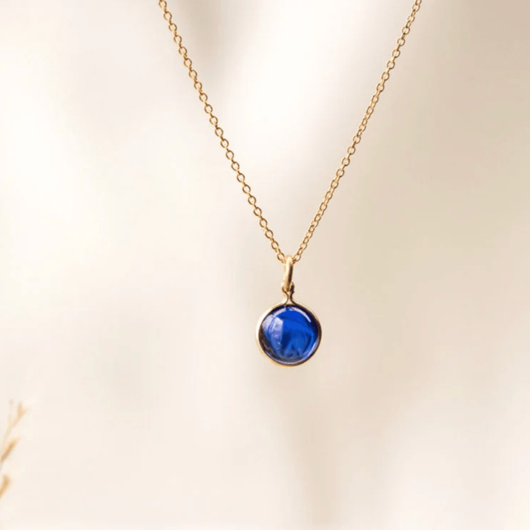 Gold necklace with blue gem, screenshot from August 27, 2025.