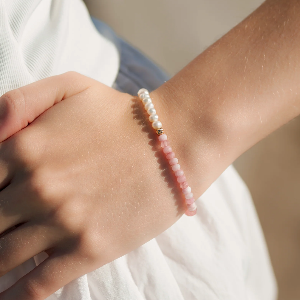 Screenshot of hand wearing pearl and pink gemstone bracelet