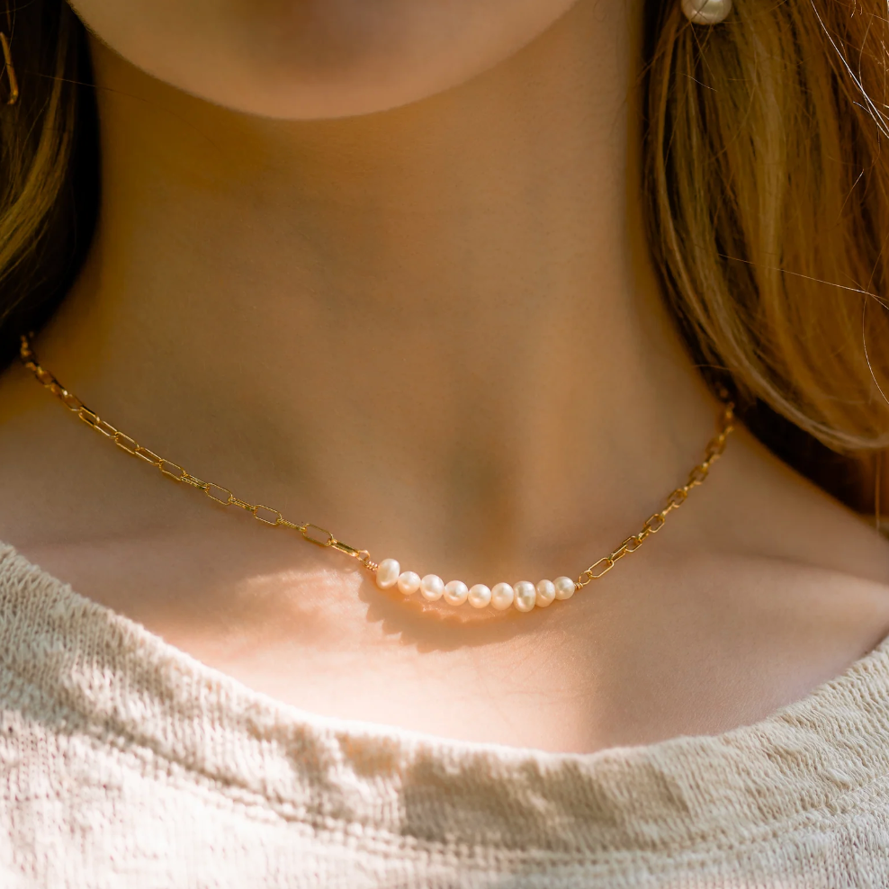 Screenshot of a pearl necklace on a woman's neck, Sept 4, 2025