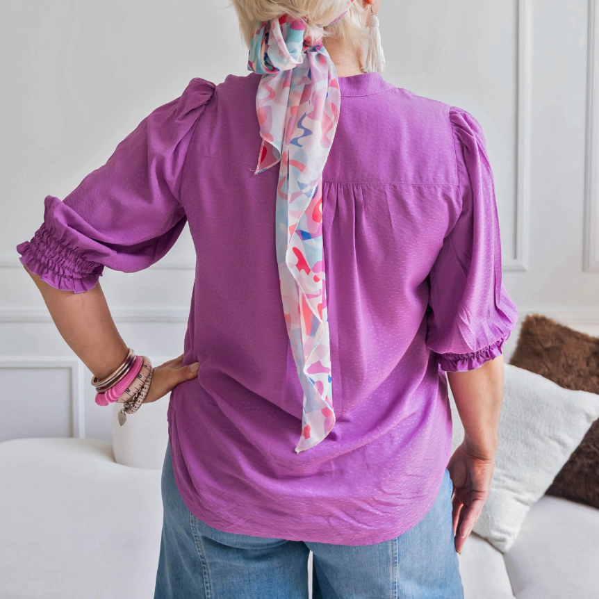 Purple blouse with scarf, screenshot Sept 9, 2025.