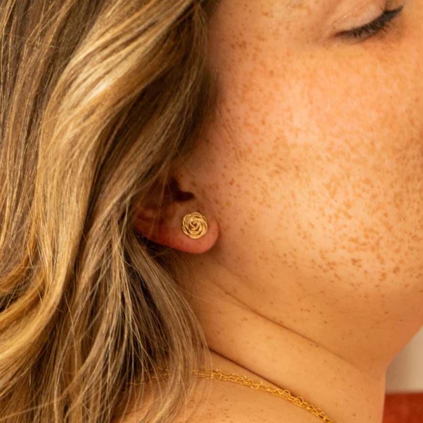 Screenshot of woman wearing gold rose stud earring, Sept 15, 2025