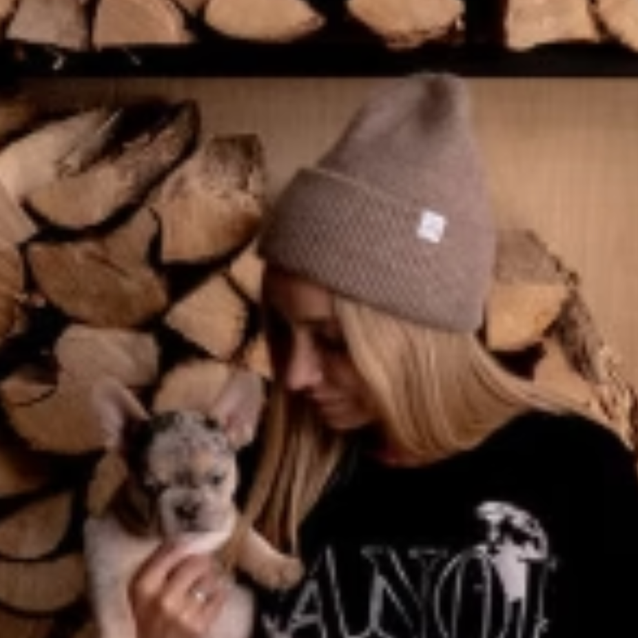 Woman holding puppy, screenshot Sept 18, 2025.