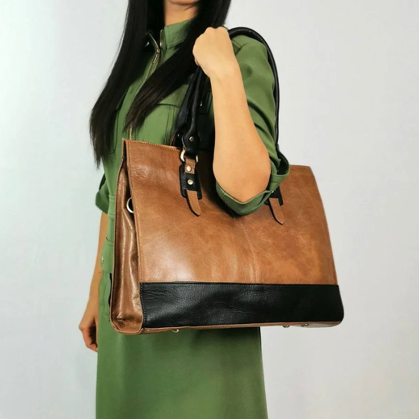 Woman in green dress holding brown and black handbag, 2025 screenshot.