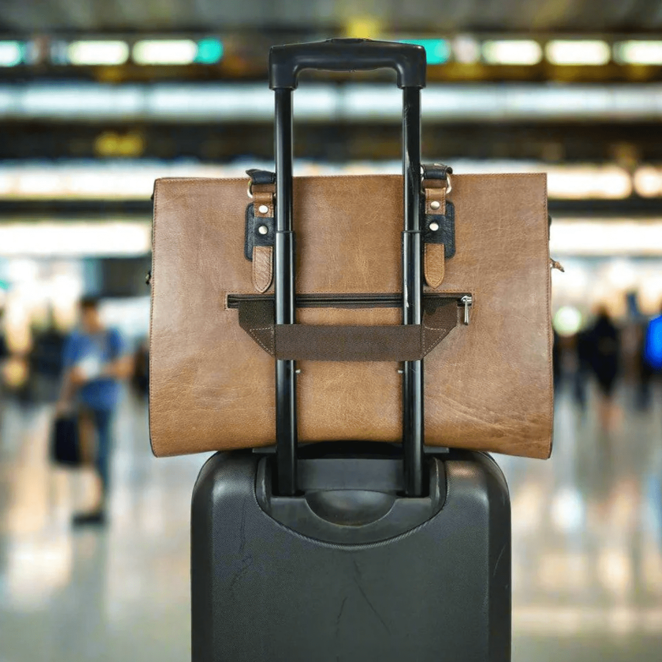 Leather bag on rolling suitcase at the airport - Screenshot Sept 18, 2025