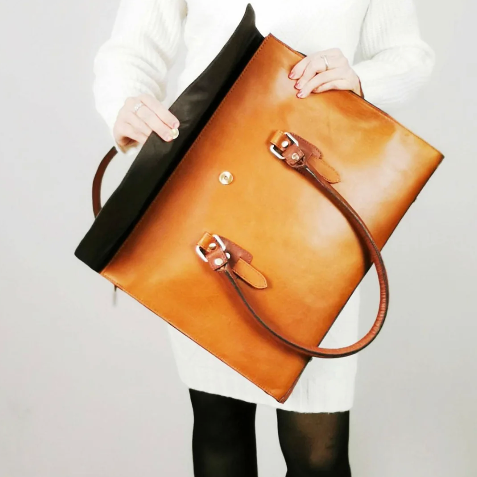 Woman holding brown leather tote bag, September 19, 2025 screenshot