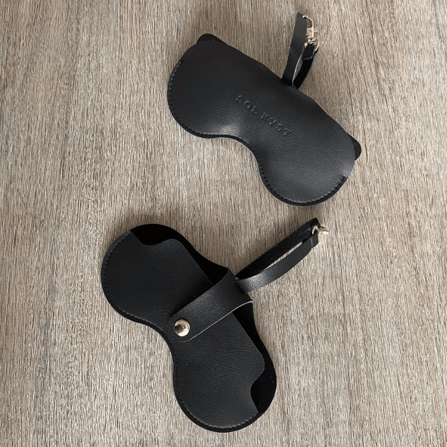 Black sunglasses cases on wooden surface, June 26, 2025