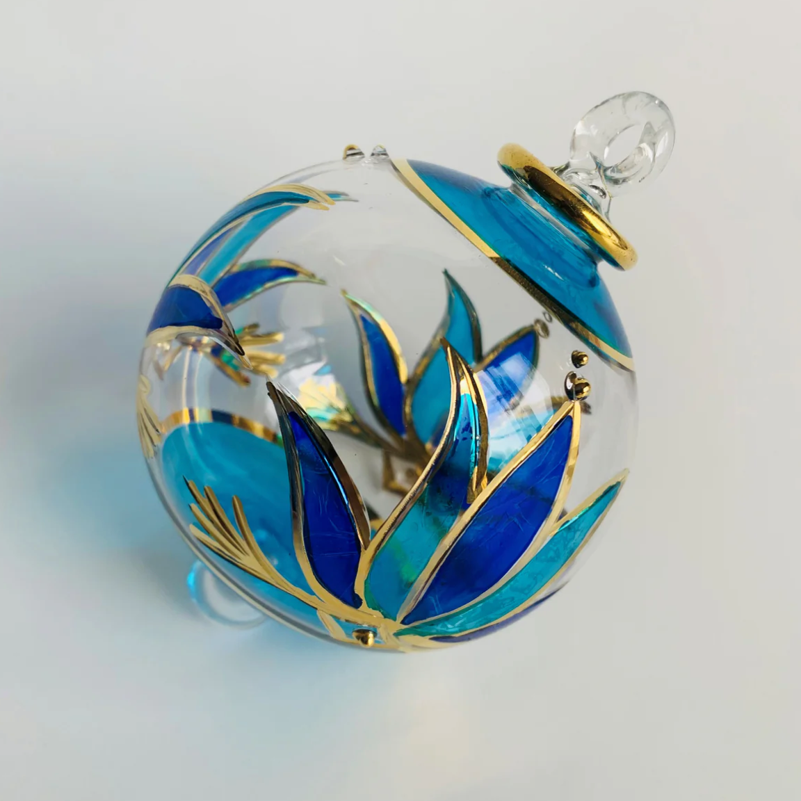 Glass ornament with blue and gold floral design, June 30, 2025.