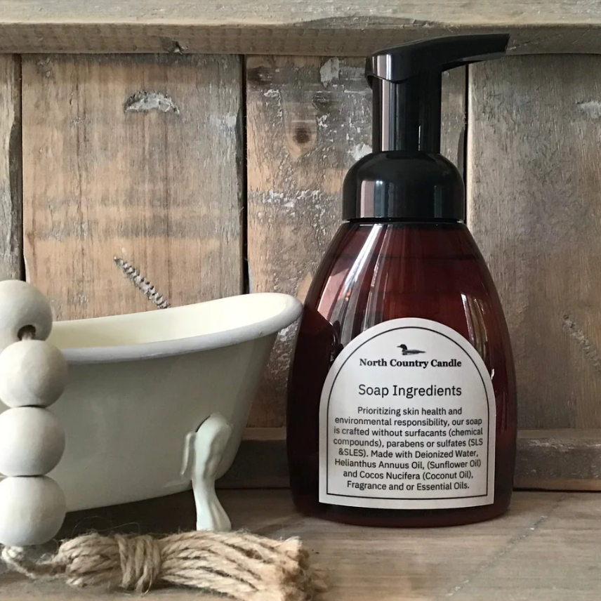 North Country Candle soap bottle next to a small bathtub.