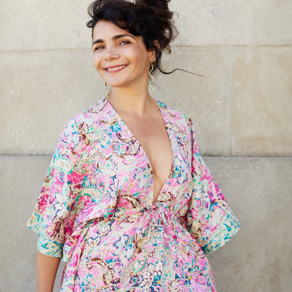 Woman in floral dress, smiling, screenshot August 16, 2025