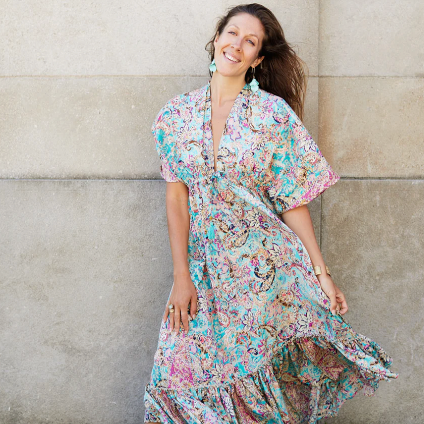 Woman in patterned dress smiling, August 16, 2025 screenshot