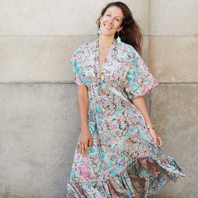 Woman in patterned dress smiling, August 16, 2025 screenshot