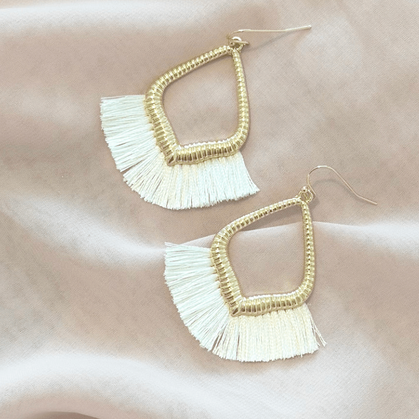 Gold and white tassel earrings, screenshot from 2025.