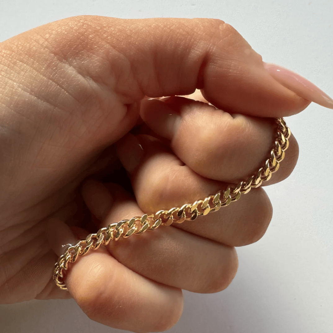 Gold chain bracelet held in hand - Screenshot August 22, 2025