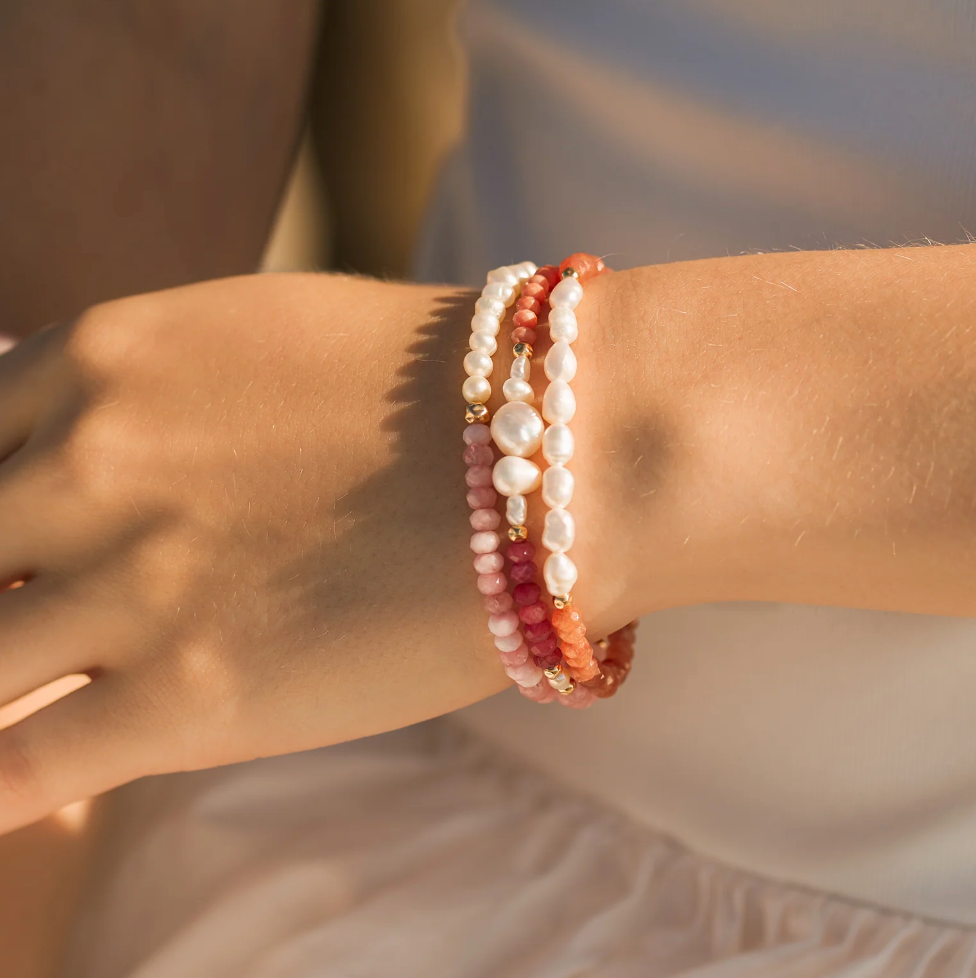 layered pearl & gemstone bracelets on wrist