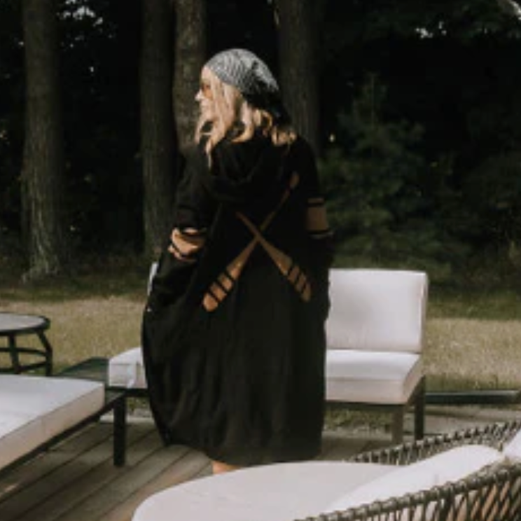 Woman in black coat with oar design, screenshot from Sept 12, 2025