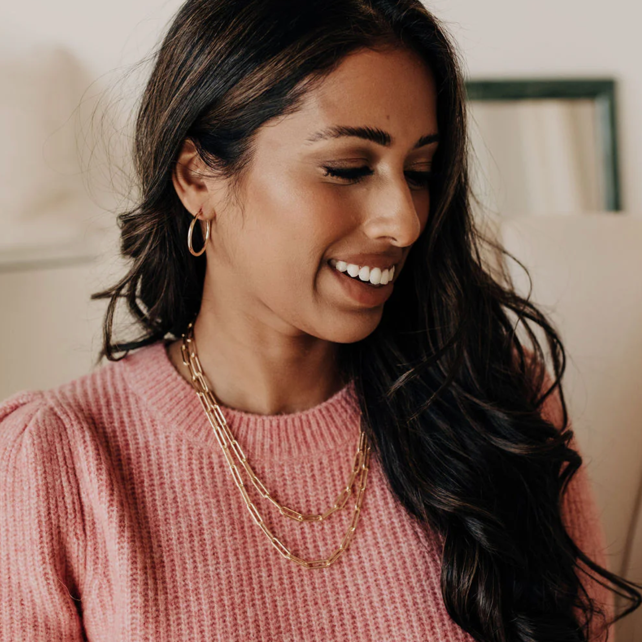 Woman wearing gold necklace and pink sweater, screenshot from Sept 15, 2025.