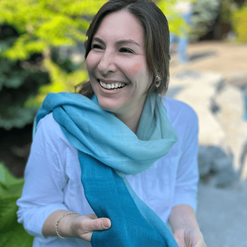 Woman smiling in blue scarf, Sept 15, 2025 screenshot.