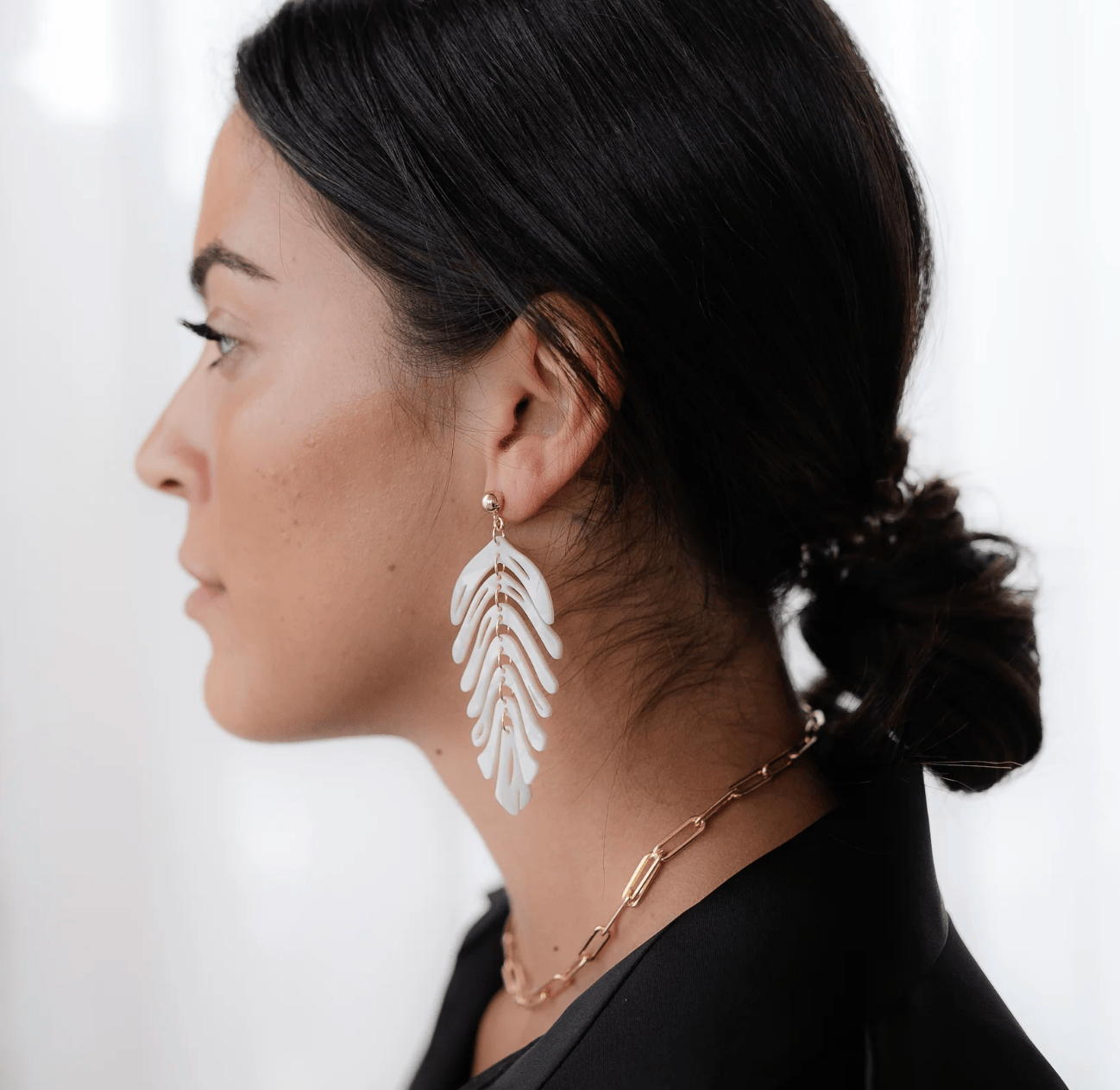 Woman wearing leaf earrings, screenshot Sept 15, 2025.